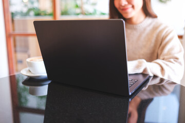 Closeup image of a woman working and typing on laptop computer keyboard