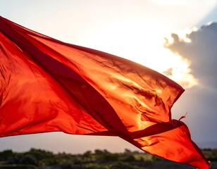 Close-up of a vibrant red flag billowing against the sun
