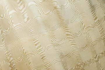 A soft beige fabric featuring a quilted, raised wave pattern