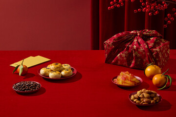 Chinese New Year setup with traditional sweets, fruit jams, and red decorative elements. Red tone creates a festive mood space for branding or typography