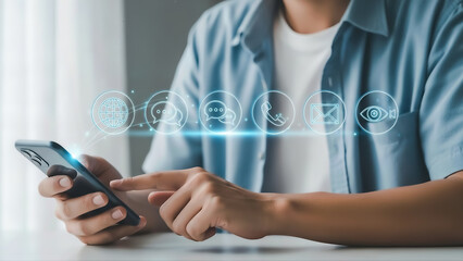 A person sitting at a table using a smartphone with social media icons floating above the screen in a modern setting