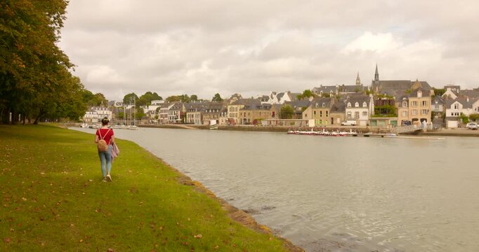 Lone Woman Strolling By The Shores Near Saint-Goustan Historic Port District In Auray, France. Wide Shot