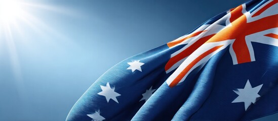 The Australian flag flutters gracefully in the wind against a bright blue sky, illuminated by the radiant sunlight, creating a patriotic and vibrant display of national pride