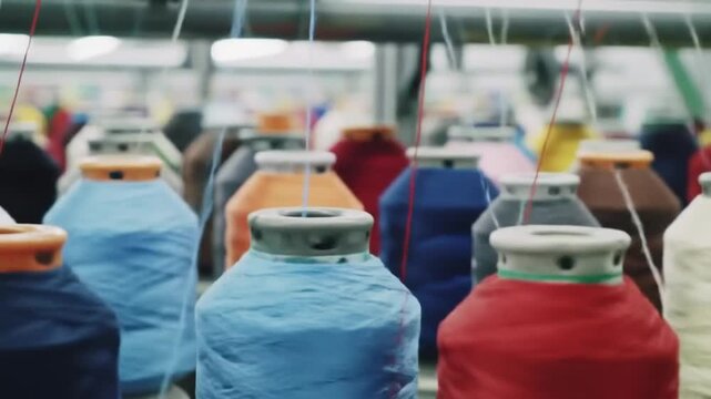 Close Up of Colorful Industrial Sewing Thread Spools on Knitting Machine in Textile Factory