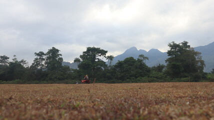 a vast field with grass and a beautiful mountain backdrop