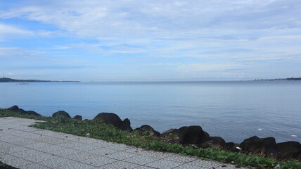 Rocks are arranged on the edge of the beach, the sea water is calm