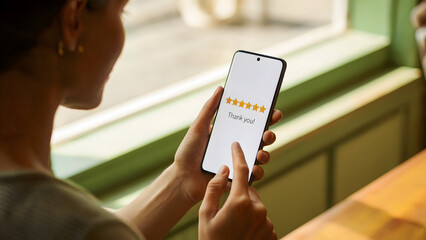 Woman holding smartphone with five star rating on screen, customer satisfaction feedback concept, thank you message review interface, digital service quality app, for business, marketing, lifestyle.