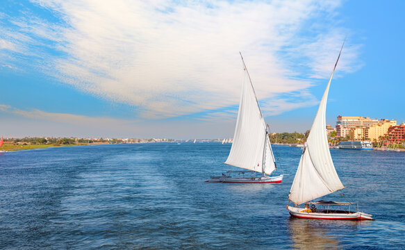 Beautiful Nile scenery with traditional Felluca sailing boat in the Nile - Aswan, Egypt