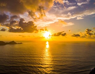 Aerial view of a radiant, golden sunset over a calm ocean
