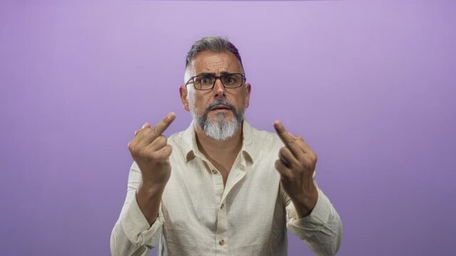 Man middle aged showing middle fingers with bare hands in studio against purple backdrop, wearing glasses and linen shirt; defiance.