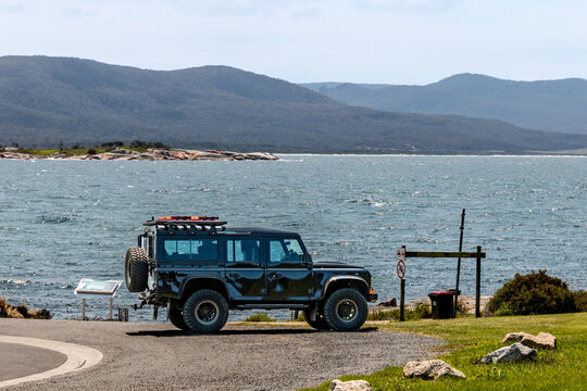 and rover vehicle parked at lookout point with view of the ocean