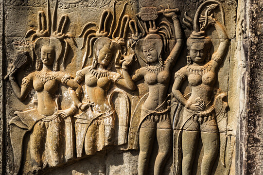 Beautiful bas-relief carving of celestial Apsara dancers with intricate details on stone wall of Khmer temple in Siem Reap Cambodia