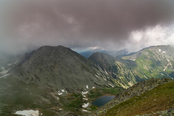 Beautiful alpine scenery, pristine glacier lake, rocks and spring flowers in the Transylvanian Alps in  early summer