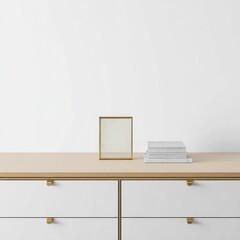 A minimalist arrangement featuring a gold-framed item and books on a light wood surface