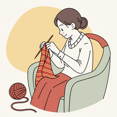 Woman knitting while sitting in a chair with yarn ball nearby  