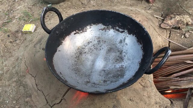 Traditional Iron Kadhai Heating over Wood Fired Earthen Stove, Rustic Outdoor Village Kitchen, Indian Cooking Equipment, 4K Stock Footage