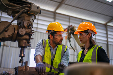 Blue collar workers are working at machine shop with CNC lathe  machine.