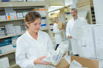 female harmacist holding medicines in pharmacy