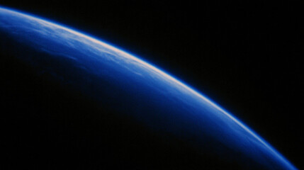 View of Earth's curved horizon from space with a dark background.