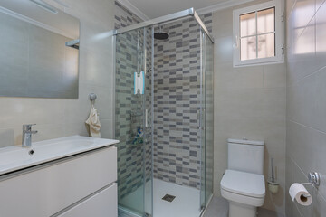 Modern bathroom with glass shower and neutral tiled walls