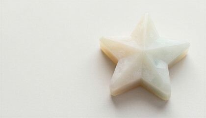 Star-like geometric form in minimalist studio style, soft-toned material, aspirational symbol with copy space