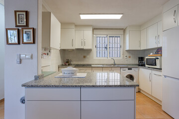 Bright modern kitchen with granite island and white cabinetry