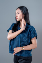 Serious Asian Woman in Side Profile With Raised Hand Gesture