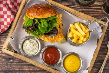 Crispy fried chicken burger served with fries and creamy dips