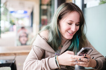 young woman using a mobile phone at a restaurant