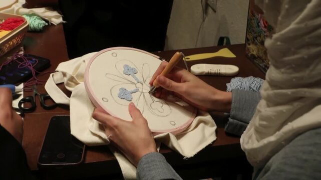Close-up of a person creating handmade embroidery with a needle