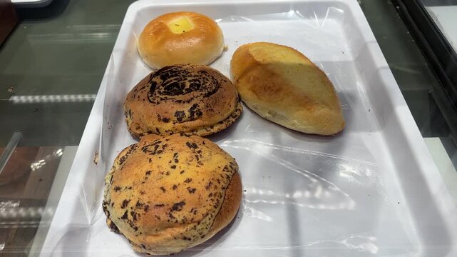 Assorted freshly baked buns including coffee mexican buns and meat floss bread in bakery