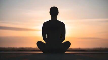 Serenity in Solitude: The silhouette of a person sits in quiet meditation against the backdrop of a radiant sunset, embracing inner peace and mindfulness.