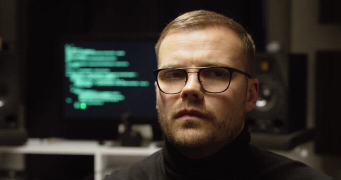 Cinematic close-up of a man wearing headphones making a disapproving &ldquo;no&rdquo; gesture, with a blurred tech screen behind&mdash;concept for AI music backlash, creator rights, authenticity, and industry debate.
