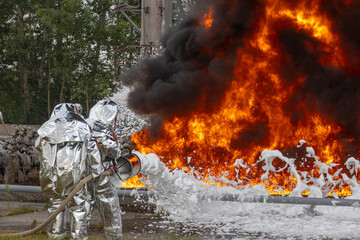 Firefighters use a foam generator to supply foam to extinguish the fire. A fire at the plant caused by the ignition of an oil product. Firefighters extinguish a fire at an oil refinery.