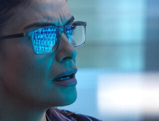 Woman looking seriously at screen reflecting binary code during cyber attack