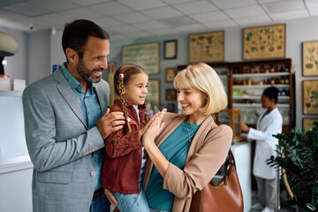 Happy family giving high-five in pharmacy.