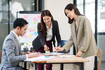 Group of Asian businesspeople sits down for a business investment planning meeting.