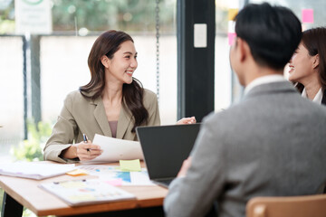 Group of Asian businesspeople sits down for a business investment planning meeting.