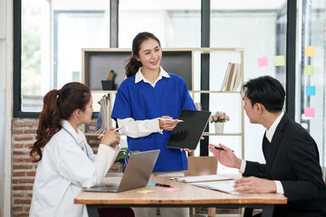 A lone Asian male doctor is working in a hospital conference room.
