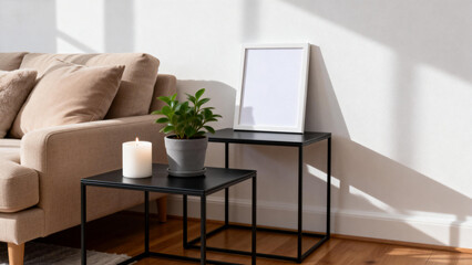 Modern living room corner with beige sofa, black metal tables, potted plant, candle, and framed artwork