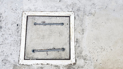 Drain Covers: A close-up shot of a concrete drain cover embedded in a rough concrete surface. The minimalist design emphasizes the contrast between textures and shapes.