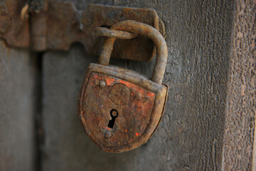 Rusty padlock on weathered door in Austria close-up
