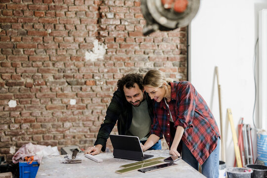 Couple planning home renovation and energy consulting at construction site