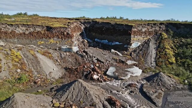 Dramatic riverbank erosion shows layers of soil and ice melting rapidly