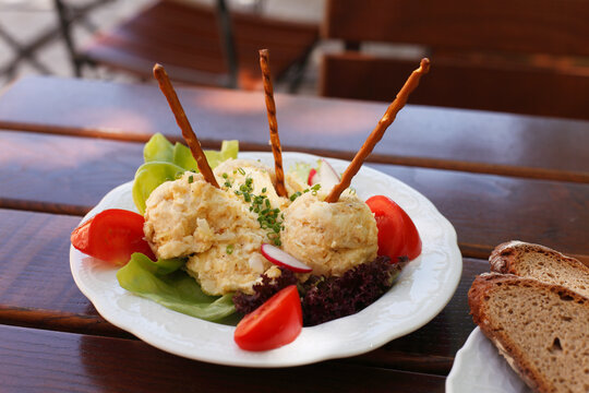 Traditional Bavarian Obatzda cheese spread served with pretzel sticks outdoors
