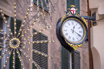 old urban wall clock on the sidewalk in the center of Genoa at Christmas time