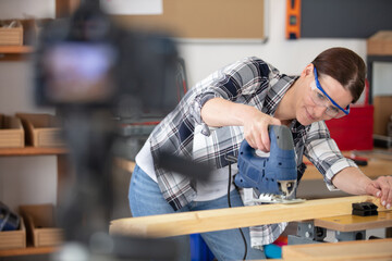 woman is doing a blog about cutting wood