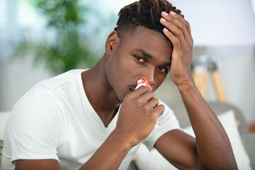 young man touching his bleeding nose
