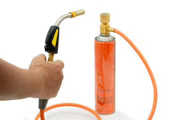 Close-up of a hand holding a gas torch connected to a fuel canister, representing industrial heating, soldering, craftsmanship, safety awareness, and professional tool usage.