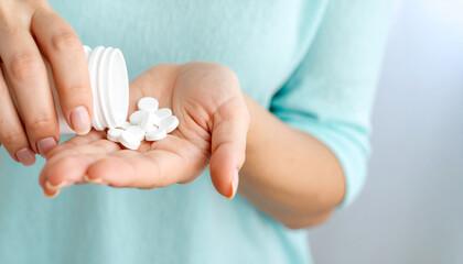 Vitamin supplement bottle hand wellness immunity health healthcare nutrition prevention daily medicine person holding white pills in palm promoting wellness and prevention